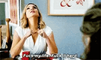 a woman sitting at a table says " fuck my life "