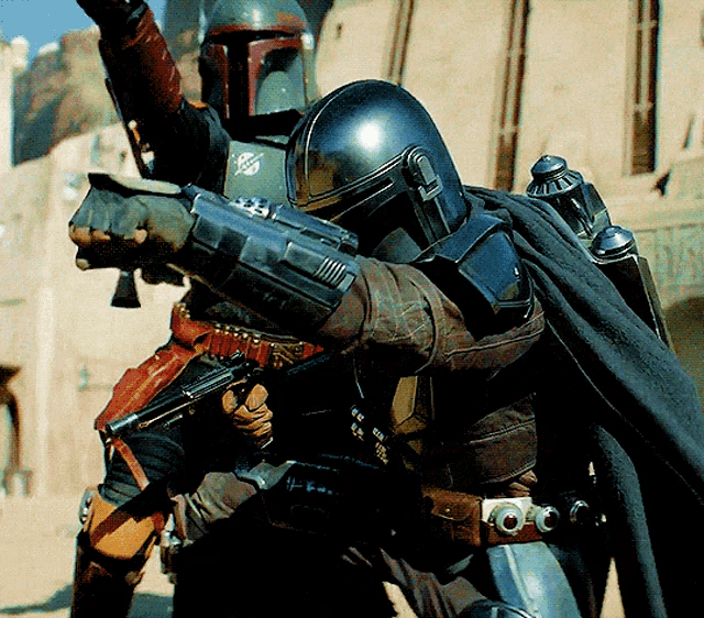 a man with a helmet on holds a gun while another man looks on