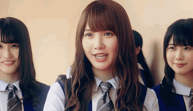 a girl with braces on her teeth is smiling while standing next to two other girls