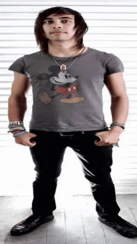 a young man wearing a grey mickey mouse shirt