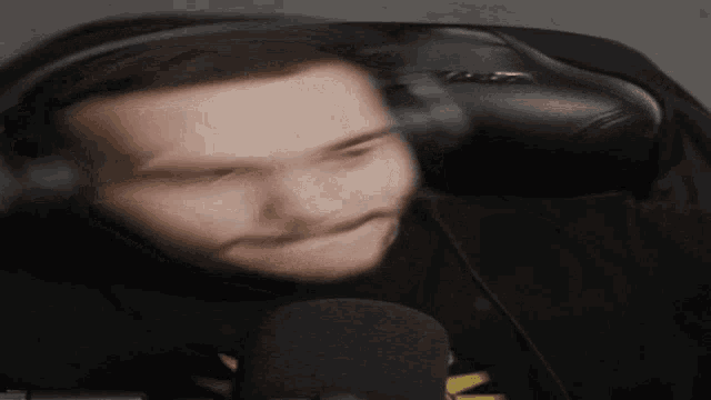 a blurry picture of a man wearing headphones and a black shirt