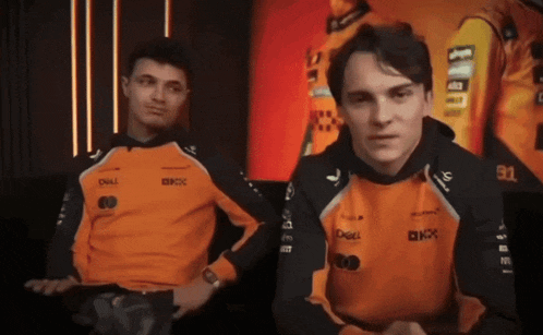 two men wearing orange shirts with dell and kx on them