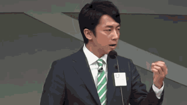 a man in a suit and tie is giving a speech at a podium .