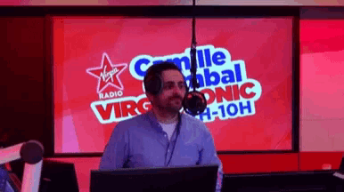 a man is standing in front of a virgin radio sign