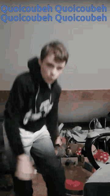 a young man is dancing in a room with the words quoicoubeh quoicoubeh quoicoubeh