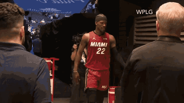 a man wearing a miami 22 jersey talks to a man in a black jacket