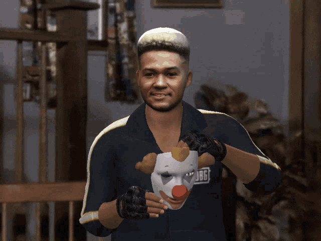 a man holding a clown mask with the pubg logo on his shirt