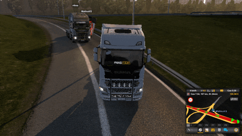 two trucks are driving down a road and one has the word taxi on the front