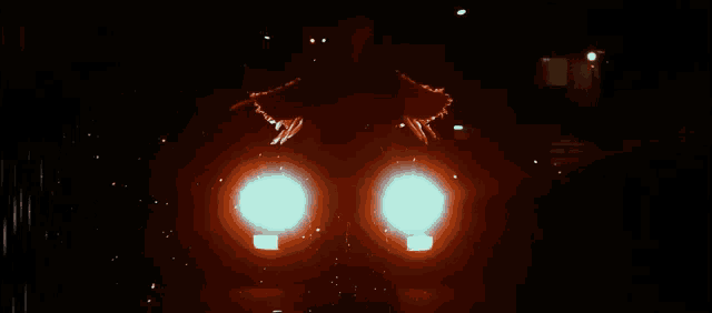 a car 's headlights are glowing brightly at night