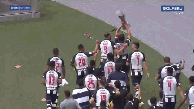a group of soccer players holding a trophy with the word gol peru on the bottom