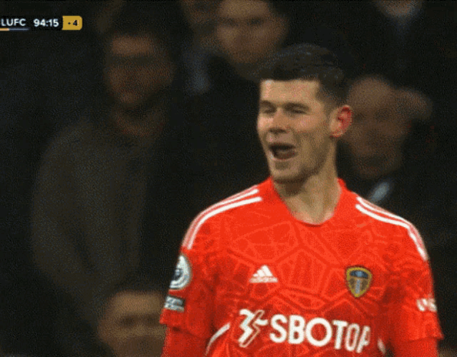 a soccer player wearing a red jersey with the word sboto on it