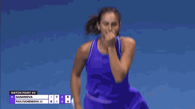 a woman in a purple tank top is standing on a blue tennis court