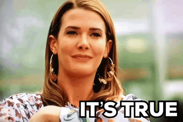 a woman is smiling and holding a piece of paper with the words `` it 's true '' written above her .