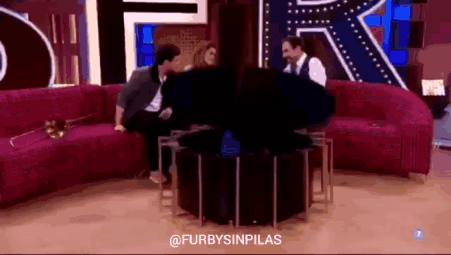 a group of people are sitting on a couch in front of a sign that says furbysinpilas on it