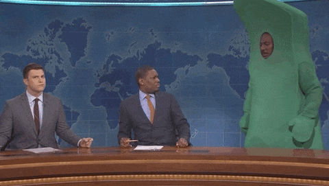 a man in a green costume is on a news desk