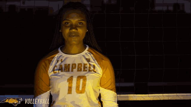 a woman wearing a campbell 10 jersey points at herself
