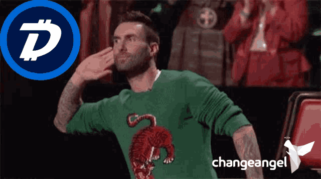 a man wearing a green sweater with a red tiger on it salutes in front of a change angel logo