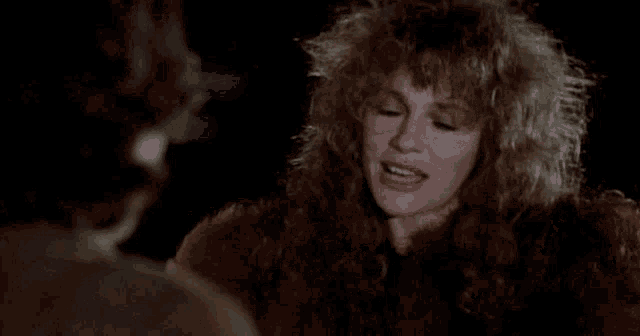 a woman with blonde curly hair is looking at another woman