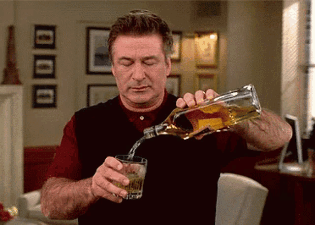 a man is pouring whiskey into a glass