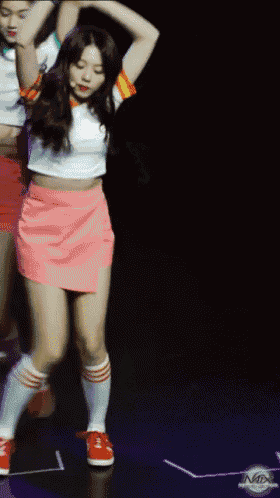 a girl in a pink skirt and white socks is dancing on stage