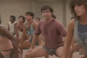 a group of people are doing stretching exercises in a room .