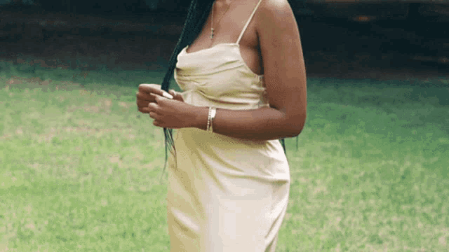 a woman in a white dress standing in the grass
