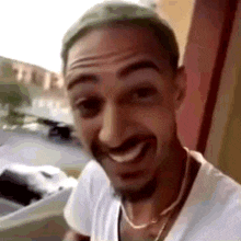 a man with a beard and a white shirt is smiling .