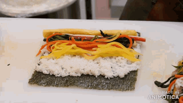 a sushi roll is being made on a cutting board with the words made in animatica on the bottom