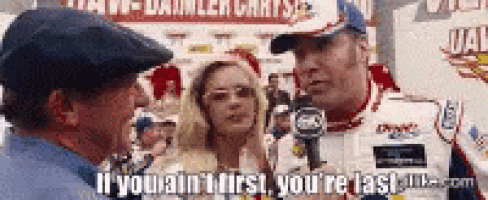 a man and a woman are talking to a race car driver in a race car .