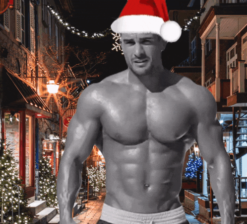 a shirtless man wearing a santa hat stands in front of a street with christmas lights