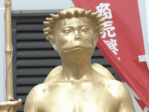 a statue of a monkey with chinese writing on a red flag