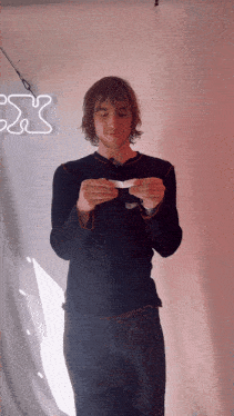 a man in a black shirt holds something in his hands