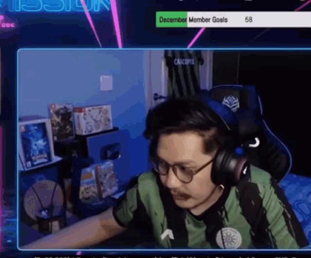 a man wearing headphones and glasses is playing a video game on a computer