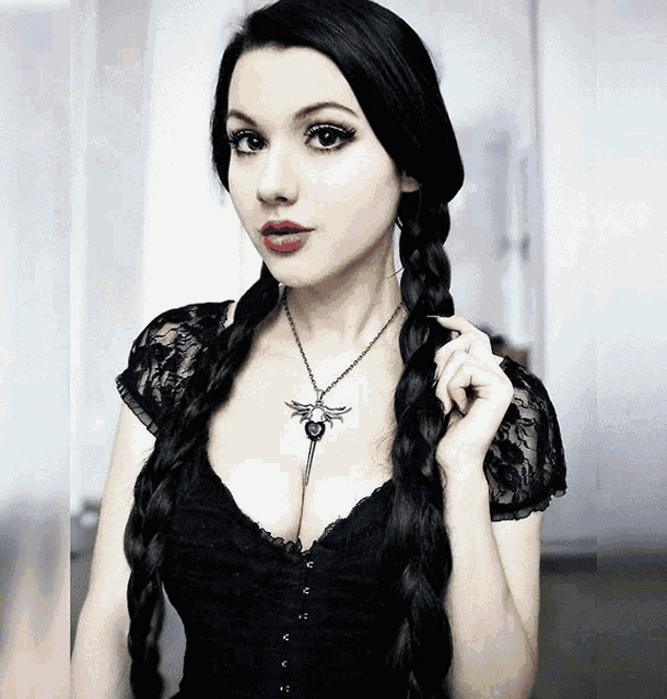 a woman wearing a black lace top and a necklace with a dragon on it