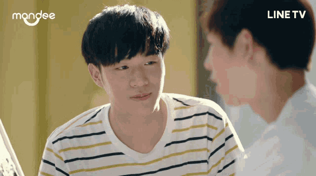 a man in a striped shirt is looking at another man in a white shirt with the word line tv on the bottom