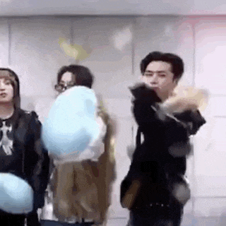 a group of people are standing next to each other holding cotton candy in a room .