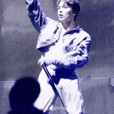 a man is standing on a stage with a microphone in his hand