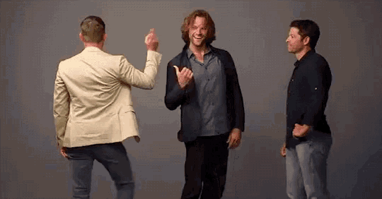 a group of men are standing next to each other and dancing .