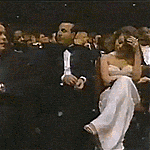a group of people including mariah carey and walter afonso sit in a dark room