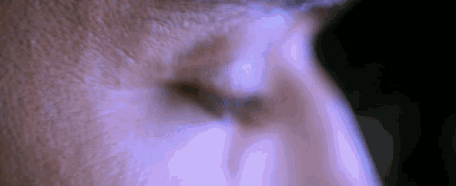 a close up of a person 's eye with a purple glow