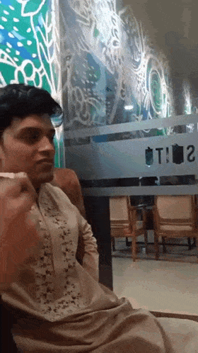 a man sitting in front of a glass door that says t2