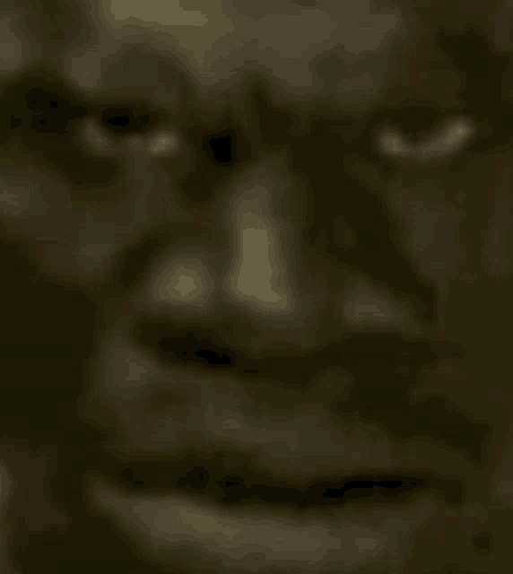a close up of a man 's face with his eyes closed and a blurred background .