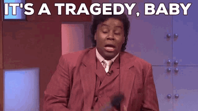 a man in a red suit says it 's a tragedy baby while holding a microphone