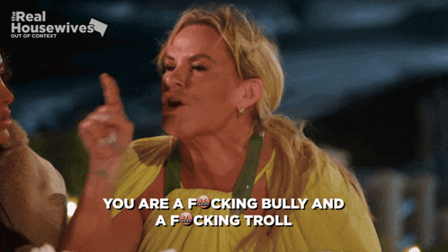 a woman in a yellow dress says " you are a fucking bully and a f cking troll "
