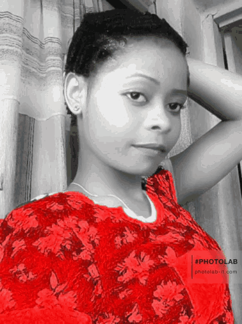a black and white photo of a woman wearing a red floral top