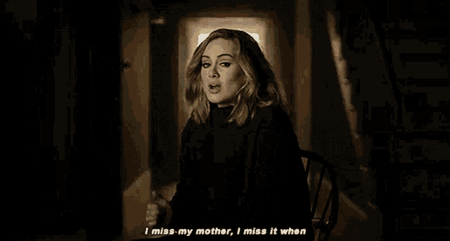 a woman is sitting in a chair in a dark hallway and saying `` i miss my mother , i miss it when ''
