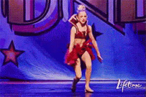 a woman in a red dress is dancing on a stage in front of a lifetime banner .