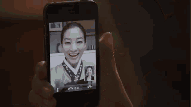 a person is holding a phone with a picture of a woman on it