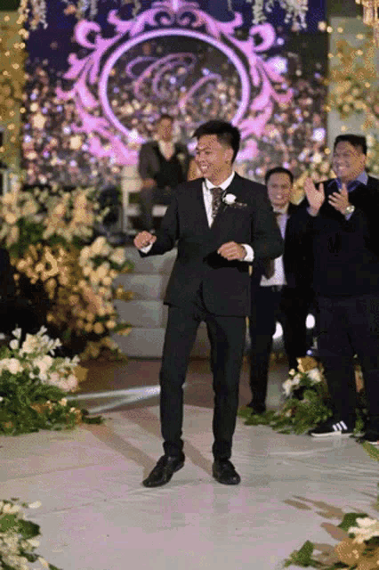 a man in a suit is dancing on a stage