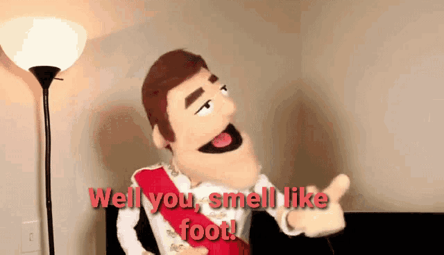 a puppet says " well you smell like foot " in front of a lamp